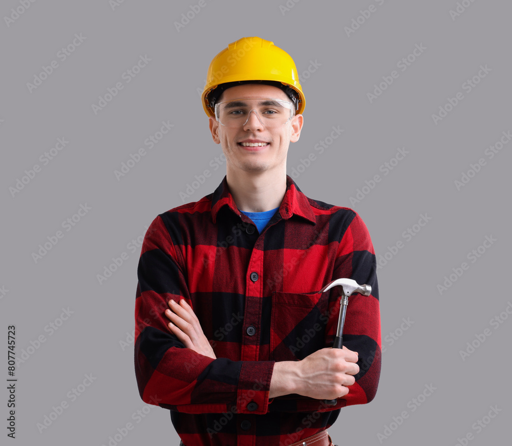 Professional repairman holding hammer on light grey background Professional repairman holding hammer on light grey background