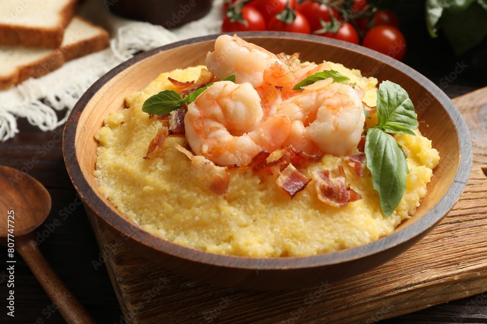 Fresh tasty shrimps, bacon, grits and basil in bowl on table, closeup