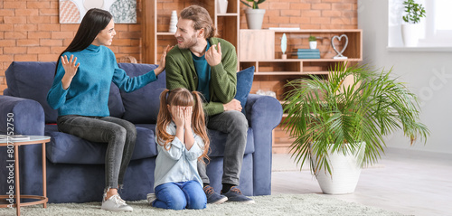 Crying little girl and her quarreling parents at home