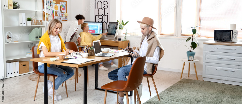 Team of graphic designers working at table in office Team of graphic designers working at table in office