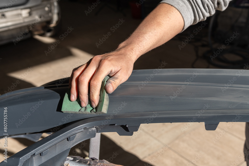 Detail of Mechanic Hand Sanding Car Bumper Detail of Mechanic Hand Sanding Car Bumper