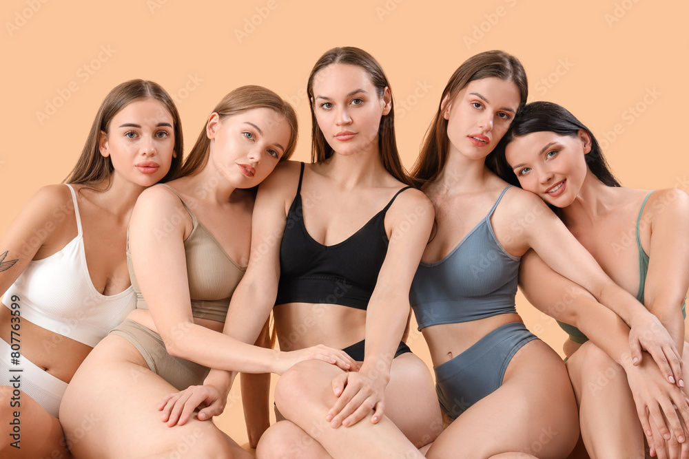 Many beautiful women in underwear on beige background