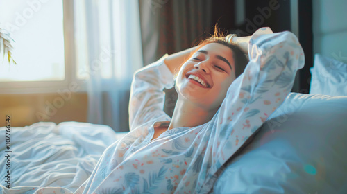 A young woman wake up in the morning sitting on white bed and stretching feeling happy and fresh