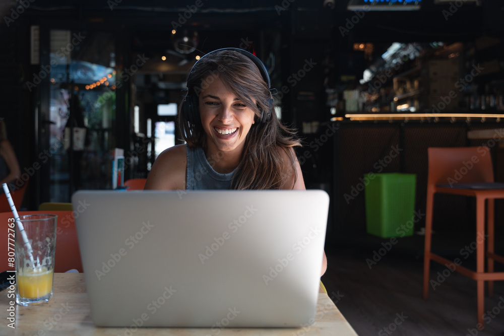 Young hipster millennial freelance woman with cool attitude, expatriate exchange student, sitting in cafeteria working online on laptop computer. Remote work online education, e-commerce telecommuting Young hipster millennial freelance woman with cool attitude, expatriate exchange student, sitting in cafeteria working online on laptop computer. Remote work online education, e-commerce telecommuting