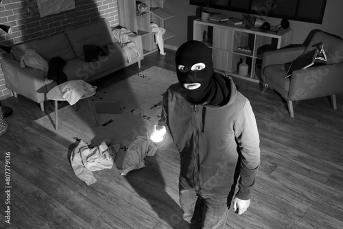 Male thief with flashlight ...
