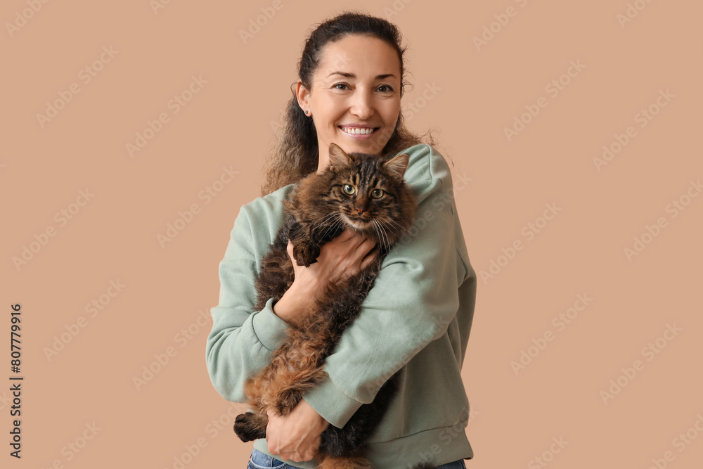 Happy mature woman with cute cat on brown background Happy mature woman with cute cat on brown background