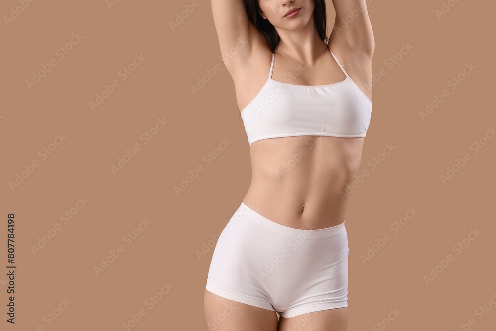 Beautiful young woman in white underwear on brown background Beautiful young woman in white underwear on brown background