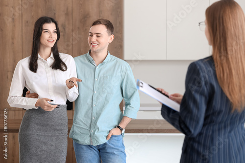 Happy young couple with real estate agent in new house