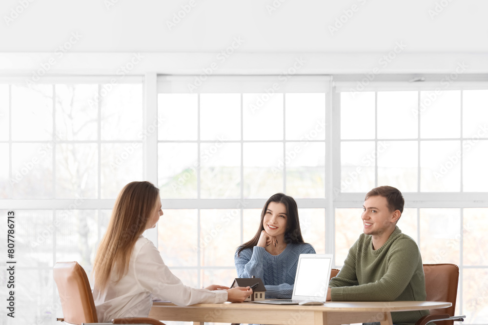 Real estate agent working with couple at table in office Real estate agent working with couple at table in office