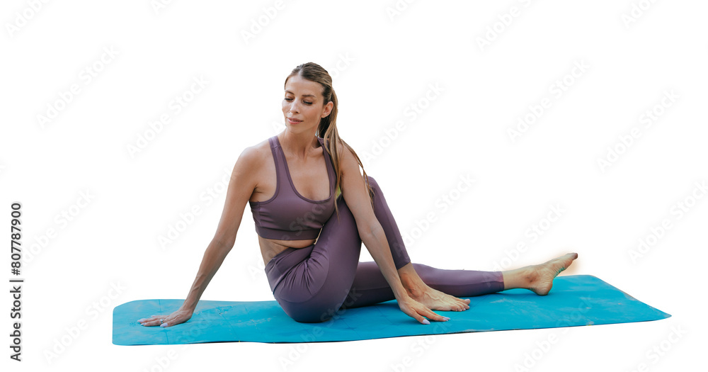 Woman practicing a seated yoga twist pose on a mat by the lakeside, peaceful outdoor setting.