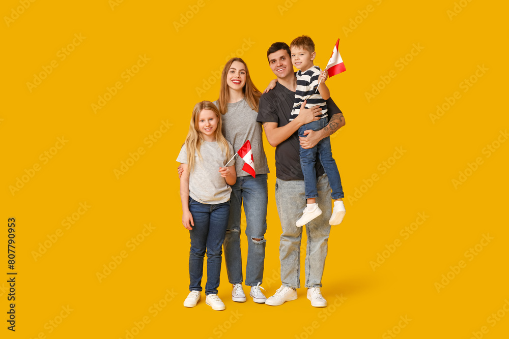 Happy family with flags of Canada on yellow background Happy family with flags of Canada on yellow background