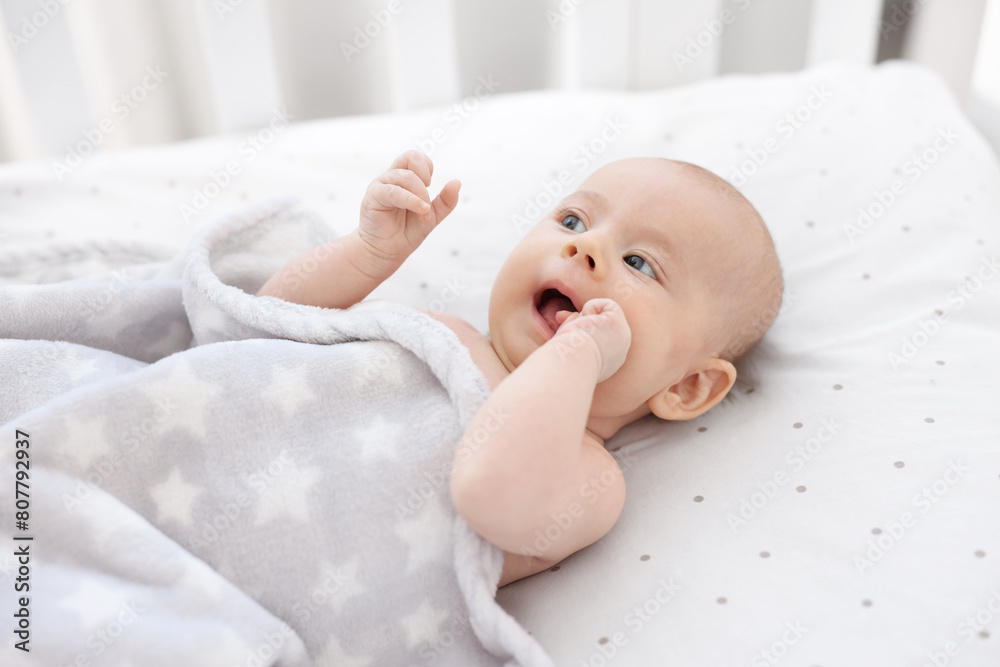 Cute little baby lying in crib at home Cute little baby lying in crib at home