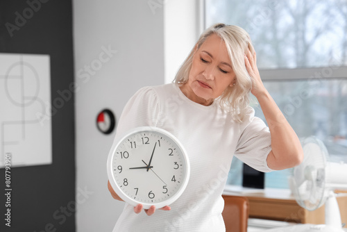 Stressed mature woman holdi...