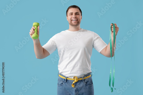 Young man with dumbbell and...