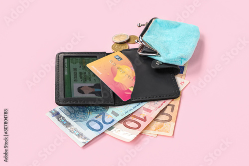 Composition with black holder, credit cards, driver's license, purse and money on pink background, closeup