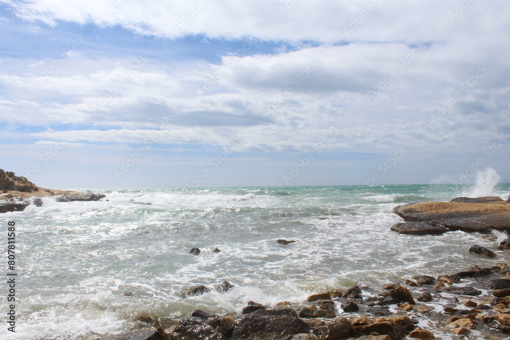 natural background of sea sky and stones, beautiful view of Mediterranean coast in Spain, waves in the sea