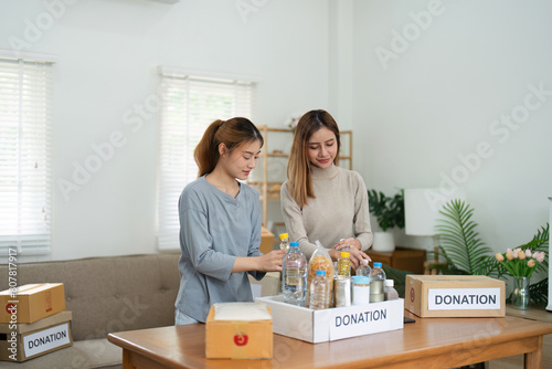 charity, donation and volunteering concept. Volunteer prepare foodstuff box containing food to donate to people poor, disaster victim at home © itchaznong