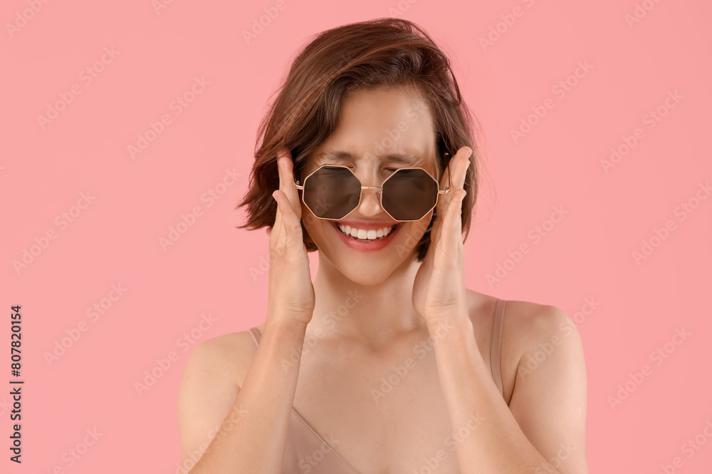 Pretty young woman with sunglasses on pink background Pretty young woman with sunglasses on pink background
