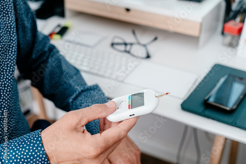 Fotografía measuring his blood glucose level in the office