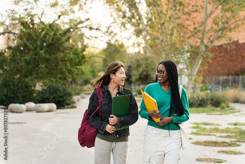 University student girl friends walking after school classes - Asian and African American women