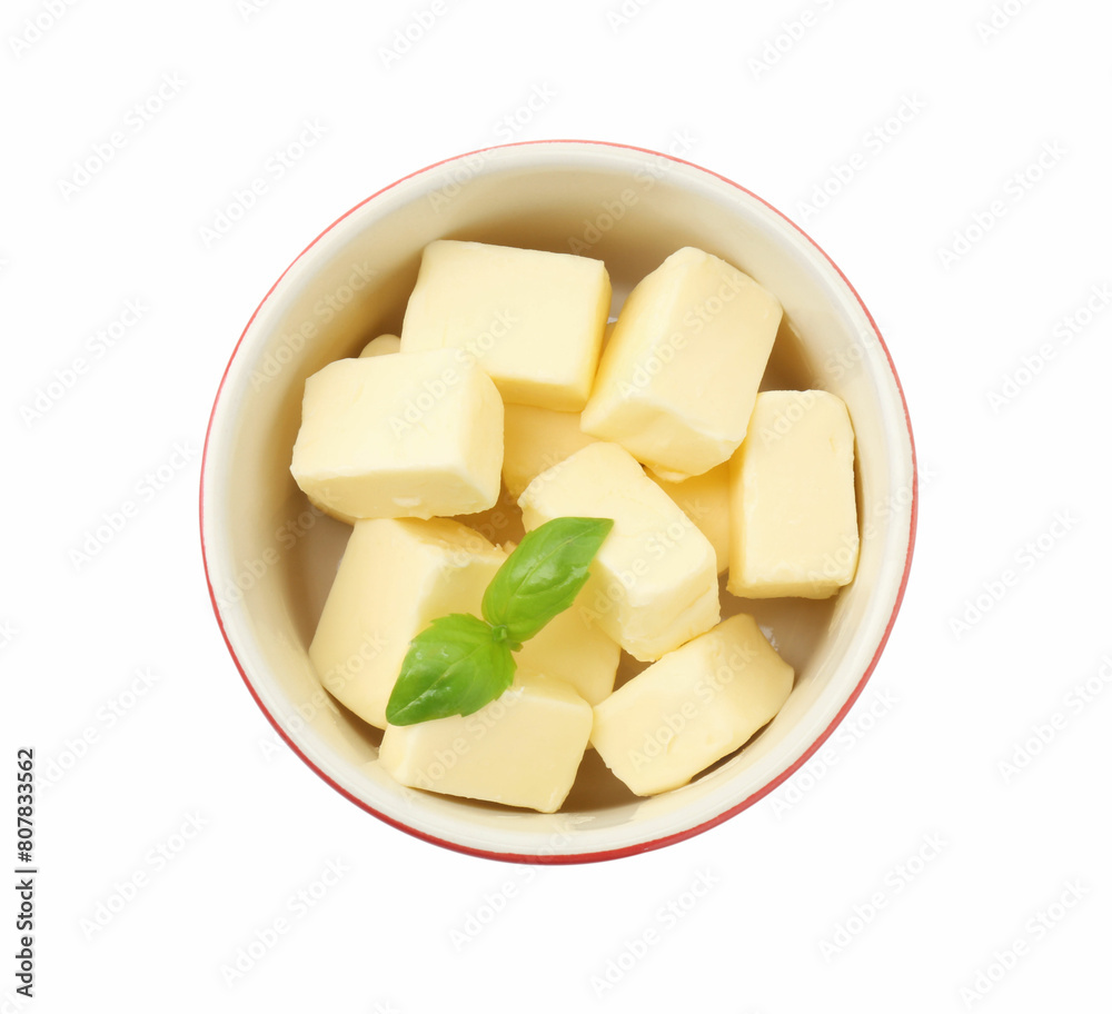 Tasty butter cubes and basil leaves in bowl isolated on white, top view Tasty butter cubes and basil leaves in bowl isolated on white, top view