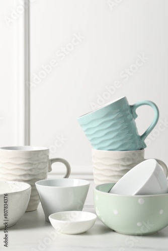 Beautiful ceramic dishware and cups on white table
