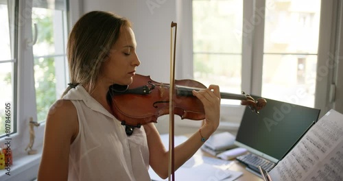 Young female violinist practicing violin at home