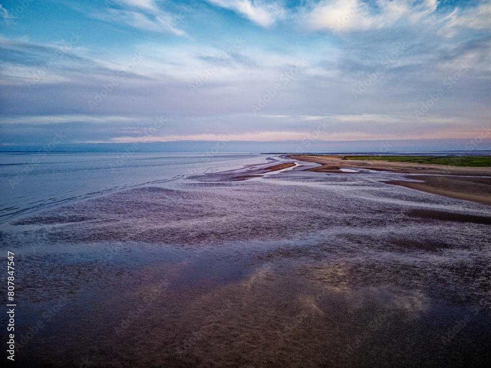 Coastal sunset scene. Aerial photograph showing tidal channels flowing through sand dunes. Lincolnshire Coast, Gibraltar Point. Summer evening sunset Coastal sunset scene. Aerial photograph showing tidal channels flowing through sand dunes. Lincolnshire Coast, Gibraltar Point. Summer evening sunset