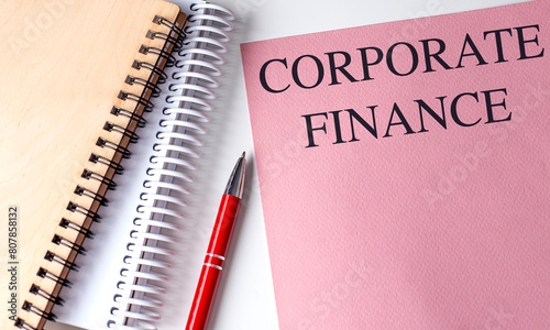 CORPORATE FINANCE text on pink paper with notebooks