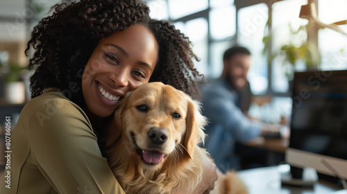 Happy african american woman cuddling olden retriever in workplace. Smiling black female businesswoman hugging holding office dog. Positive company culture & morale. Office pet photo