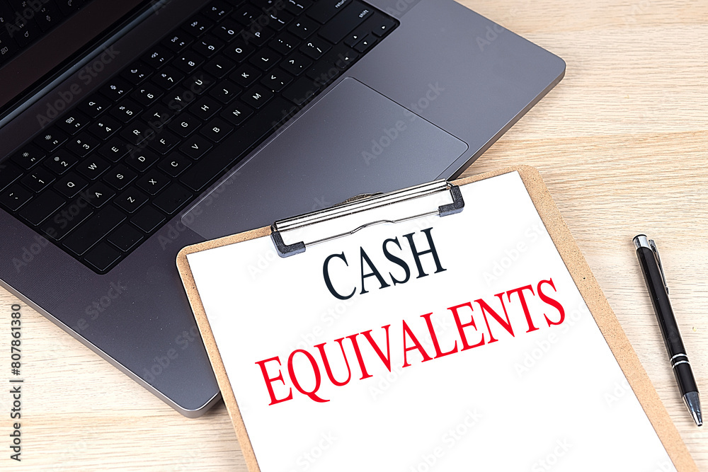 CASH EQUIVALENTS text on clipboard on laptop CASH EQUIVALENTS text on clipboard on laptop
