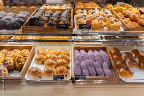 Assorted pastry and bread arranged on tray selling at bakery shop.
