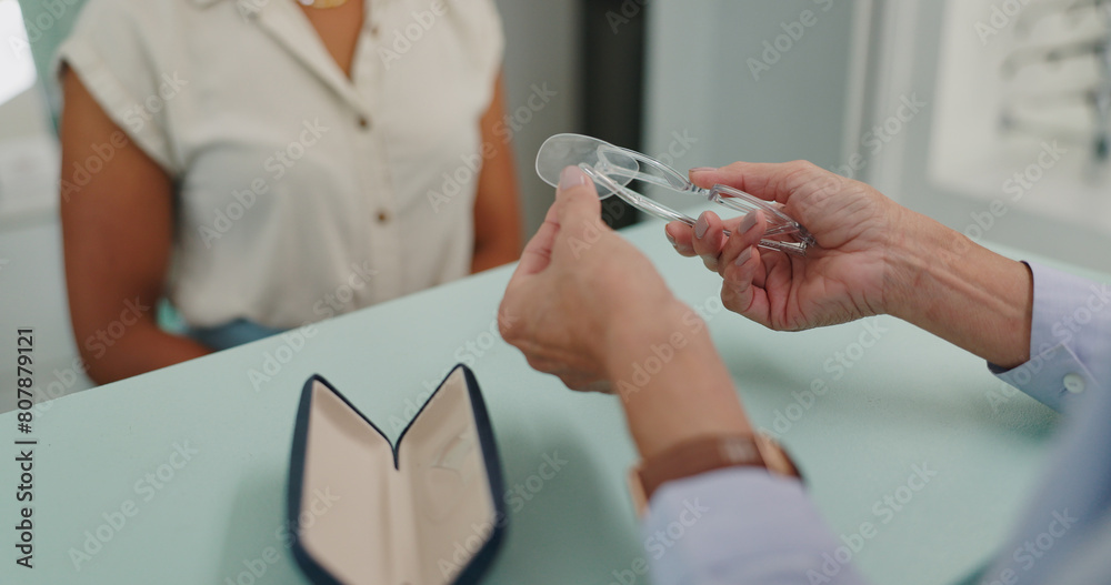 Obraz premium Glasses, optician and hands of person at shop for choice, decision or client buying. Closeup, optometry or customer at store with lens for spectacles, frame or eyewear on sale for healthy vision
