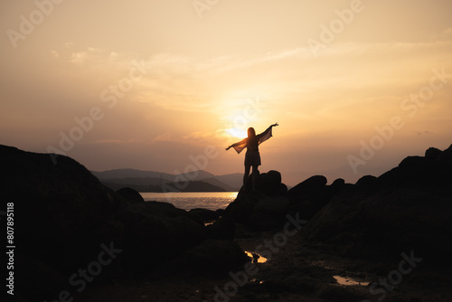 silhouette of a person on a big rock formation 