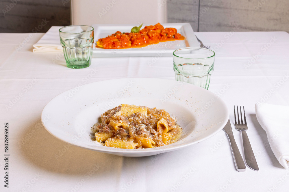 Rigatoni con sugo di genovese napoletana fatta con cipolle e carne e guarniti con formaggio grattugiato serviti come primo piatto in un ristorante 