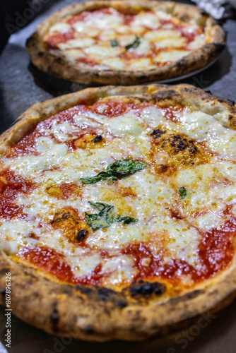 Tradizionali pizze margherita napoletane con sugo di pomodoro, mozzarella e basilico fresco appena sfornate e pronte per essere servite in una pizzeria