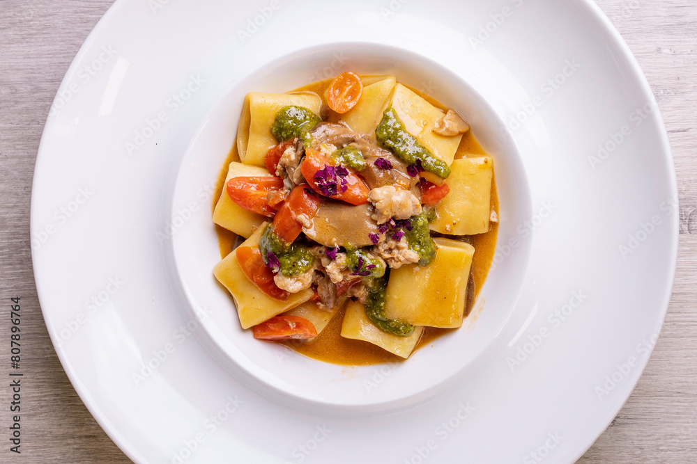 Piatto di Paccheri napoletani con funghi, salsiccia, pesto e pomodori serviti in un ristorante elegante come primo piatto Piatto di Paccheri napoletani con funghi, salsiccia, pesto e pomodori serviti in un ristorante elegante come primo piatto