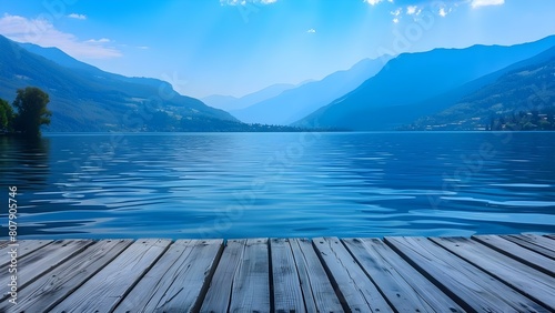 Tranquility of a serene lake with mountains in the background on an empty table. Concept Nature, Peaceful, Lake, Mountains, Serenity © Anastasiia