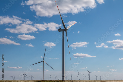 Large wind park in a field on a clear sunny day