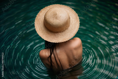 Asian girl in straw Hat  in riverl. Female back. Young beautiful woman relaxing in water photo