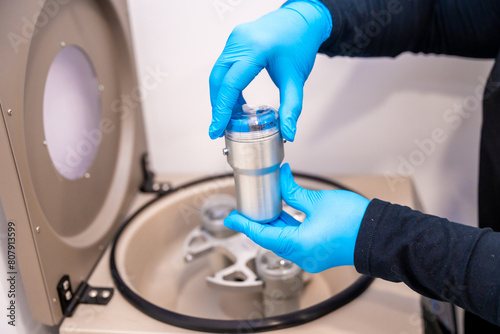 Expertise placing samples in a centrifuge machine in a laboratory © unai