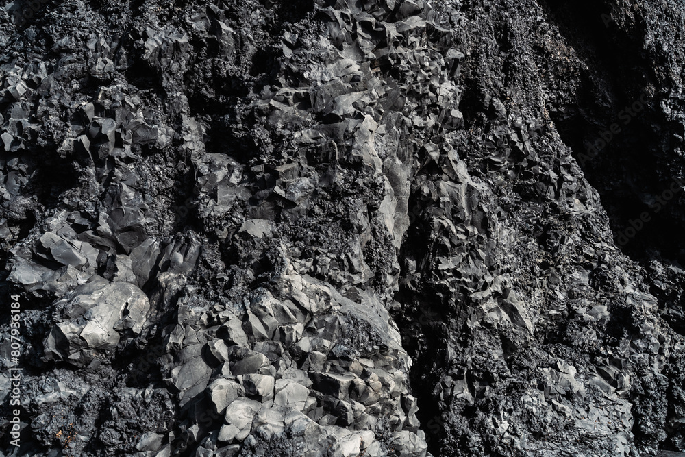 Wet basalitic rock texture. Pattern, geometry, geology, light reflections. Structure of rocks inside a cave. Icelandic black beach.