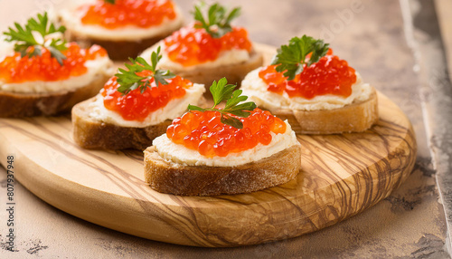 Bruschetta with cream cheese and red caviar on wooden board. Delicious snack. Tasty delicacy.