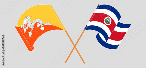 Crossed and waving flags of Bhutan and Costa Rica