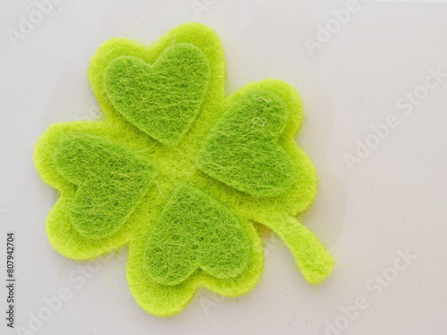A green shamrock with four hearts on it