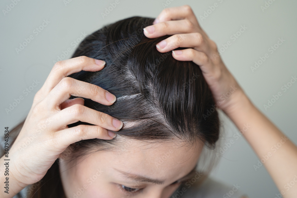 Naklejka premium Young woman worrying about her thin hair and hair fall