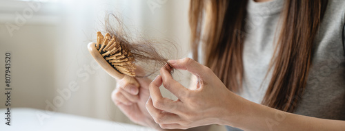 Close-up young woman brushing her hair and have many hair loss on the comb photo