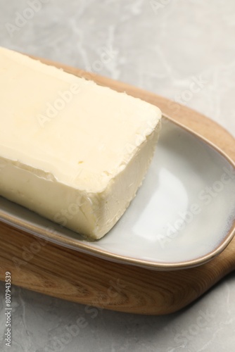 Block of tasty butter on grey table, closeup