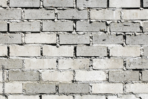 Gray uneven bricks. Home building background. Bricklayer bad job. Cement grout fugue. Masonry texture.