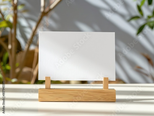 horizontal postal card in wooden stand, on top of a table